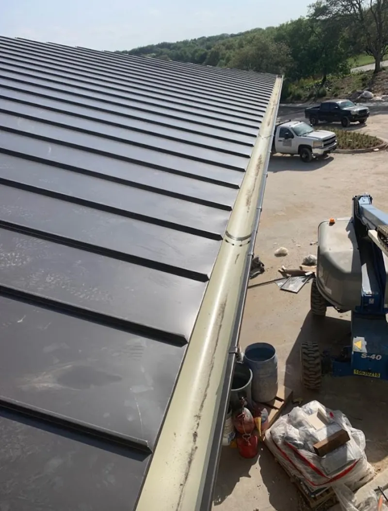 Standing seam panel and gutter detail on a metal roofing jobsite in Waxahachie
